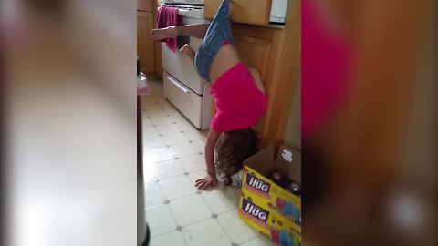 Little Girl Hangs By Her Shorts On Drawer Handle