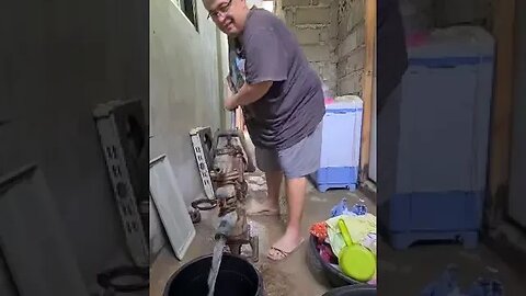 OLD FOREIGN GUY PUMPING WATER IN PHILIPPINES PROVINCE