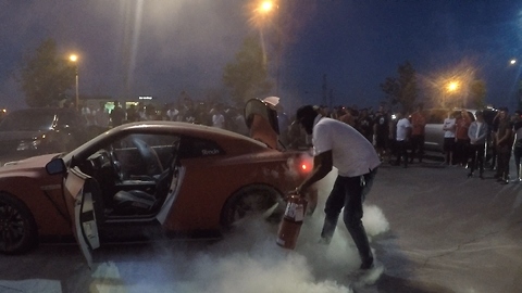 Crowd cheers as masked hero extingishes supercar that caught on fire