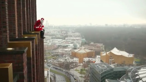 Ditching the traditional chimney, Santa Claus in Berlin scales a high-rise tower to deliver presents