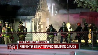 Firefighter briefly trapped in burning garage