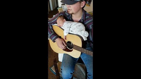 Dad Puts Baby Down For A Nap In A Special Spot - His Guitar!