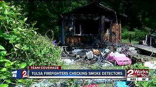 Firefighters check residents' smoke detectors after fatal fire