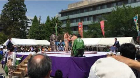 Sumo wrestlers compete to make babies cry