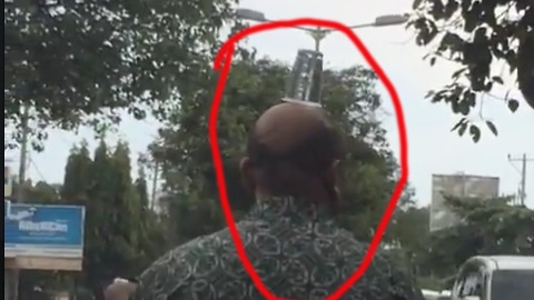 Balancing Act: Balancing Cup On His Head While Riding Motorcycle