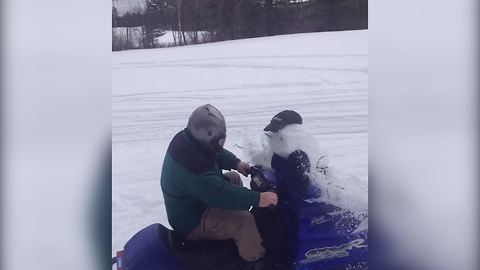 "Man Riding Snowmobile Crashes Into Snowman and Destroys It"