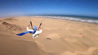 Jovem faz paragliding sobre praia marroquina