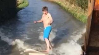 Jovem aproveita inundações para fazer surf