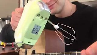 Guitarist spiller 'Pulp Fiction' temasang med en håndmixer