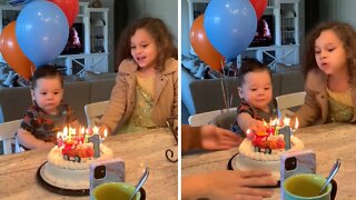 Excited baby uses his hand to put out birthday candles