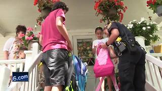 Green Bay Police officers handing out backpacks in community