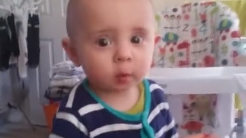 Cute baby saying no to raspberry in a funny way - I don't like it daddy