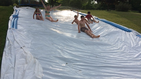 Children celebrate end of school with homemade slip-n-slide