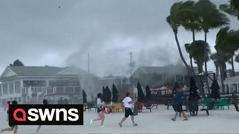 Beachgoers run for cover as waterspout turns into TORNADO at Florida beach resort
