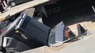 Camião do lixo cai dentro de centro comercial após estacionamento ceder