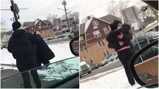 Une femme offre un manteau à un SDF, après l'avoir vu dehors, dans le froid