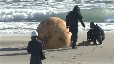 Unidentified iron ball on the sand?metal sphere