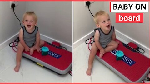 Toddler giggles as he sits on exercise board