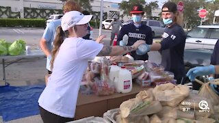 Volunteers distribute food at Palm Beach Outlets