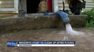 Residents begin to clean up after floods