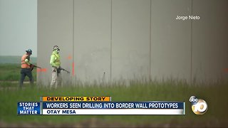 Workers seen drilling into border wall prototypes