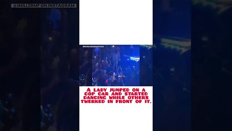 A lady jumped on a cop car and started dancing while others twerked in front of it.