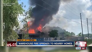 Warehouse fire spreads to nearby homes