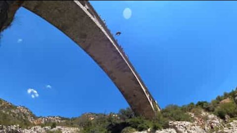 Ce jeune fait un plongeon impressionnant depuis le haut d'un pont
