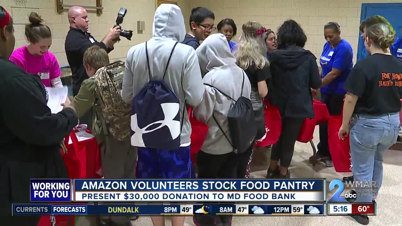 Amazon volunteers stock food pantry, present donation