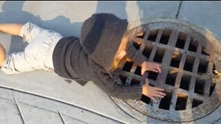 2-year-old girl talks into a sewer
