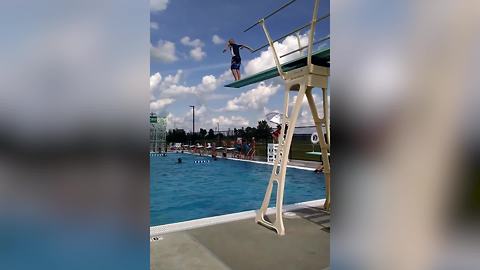 A Young Boy Does A Cannonball Off A Diving Board
