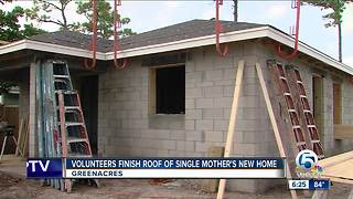 Volunteers finish roof of single mother's new home