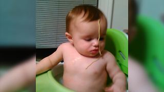A Baby Boy Fails Reaching A Noodle Stuck To His Face