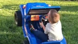 Little boy drives toy car like a bucking bronco