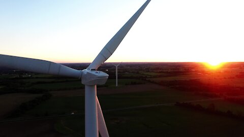 Drone accidentally records stunning sunset behind gigantic wind turbines