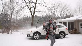 Jovem limpa neve de carro com paramotor
