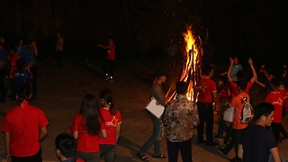 Funny dancing by fire at campfire in the forest