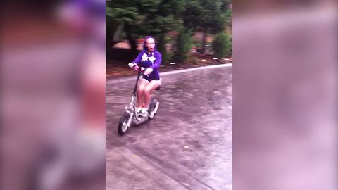"Girl Falls Off Scooter When She Tries To Stop On Wet Driveway"