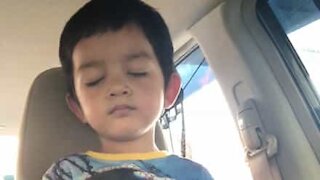 Menino dorme de pé no carro