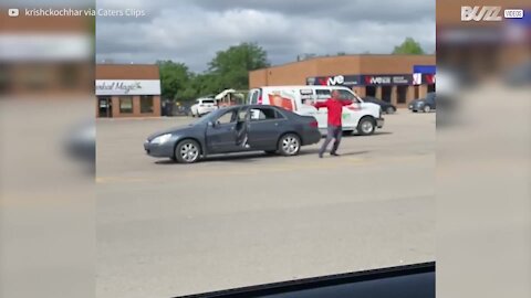 Un homme sort de sa voiture et commence à danser sur un parking