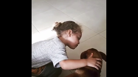 Little boy gives his dog sweet kiss
