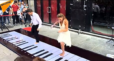 Funny couple having fun with Grande Piano