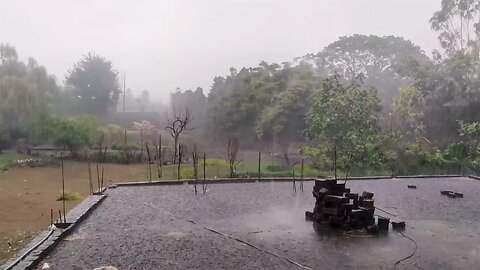 Heavy rain over bricks on a concrete foundation in a landscape setting