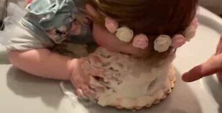 Baby stikker hele ansigtet ned i sin fødselsdagskage