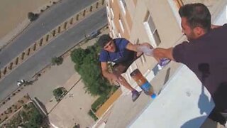 Jovem faz o "bottle flip challenge" pendurado de um edifício