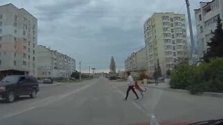 Woman and dog cross road hand in paw