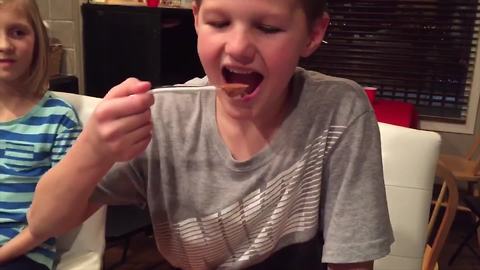 A Boy Eats A Spoonful of Cacao Powder