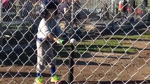 "A tot boy hits a ball off of a tee with his hands during a tee ball game"