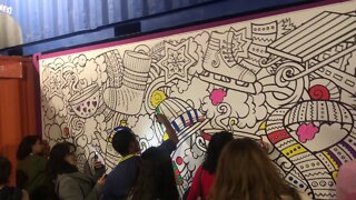 Youth paint a large picture about christmas on the wall