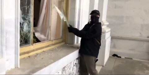 Masked Man wearing earpiece was caught on video breaking a Capitol window, Not added to FBI's list